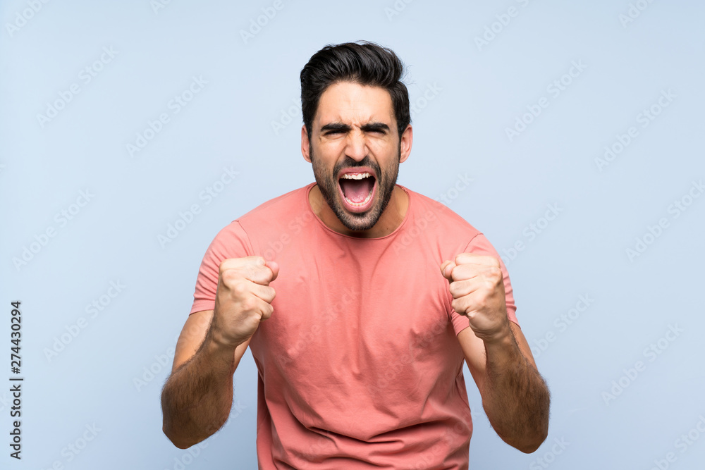 Handsome young man in pink shirt over isolated blue background frustrated by a bad situation Handsome young man in pink shirt over isolated blue background frustrated by a bad situation