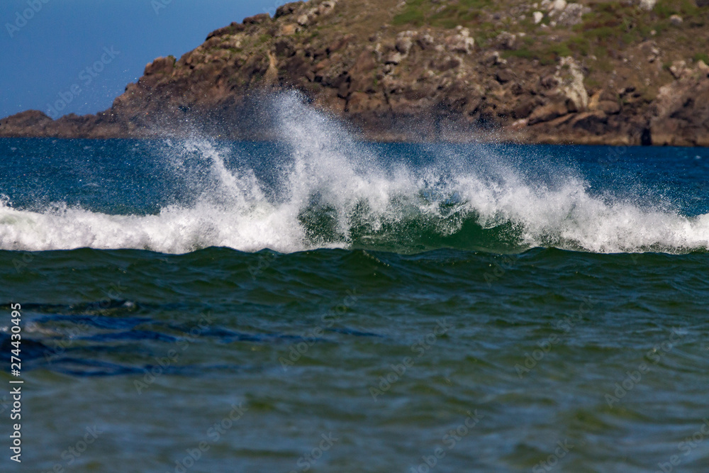 Naklejka premium waves crashing on rocks