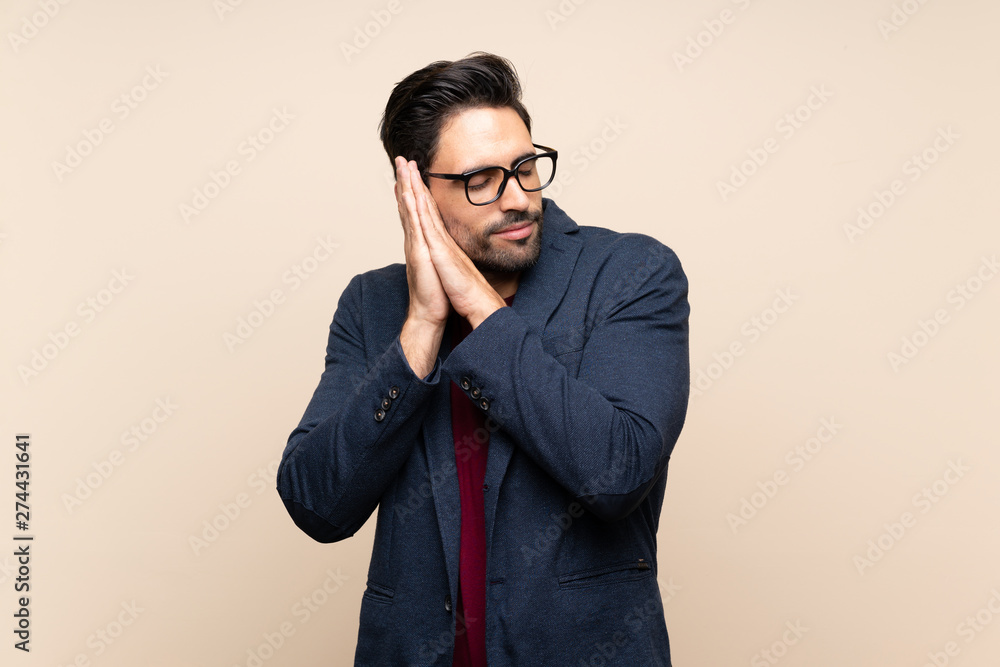 Handsome young man over isolated background making sleep gesture in dorable expression Handsome young man over isolated background making sleep gesture in dorable expression