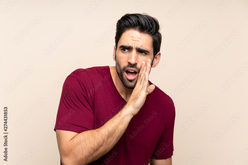 Handsome young man over isolated background whispering something Handsome young man over isolated background whispering something