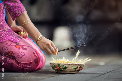 woman praying and  leaves gods offerings photo