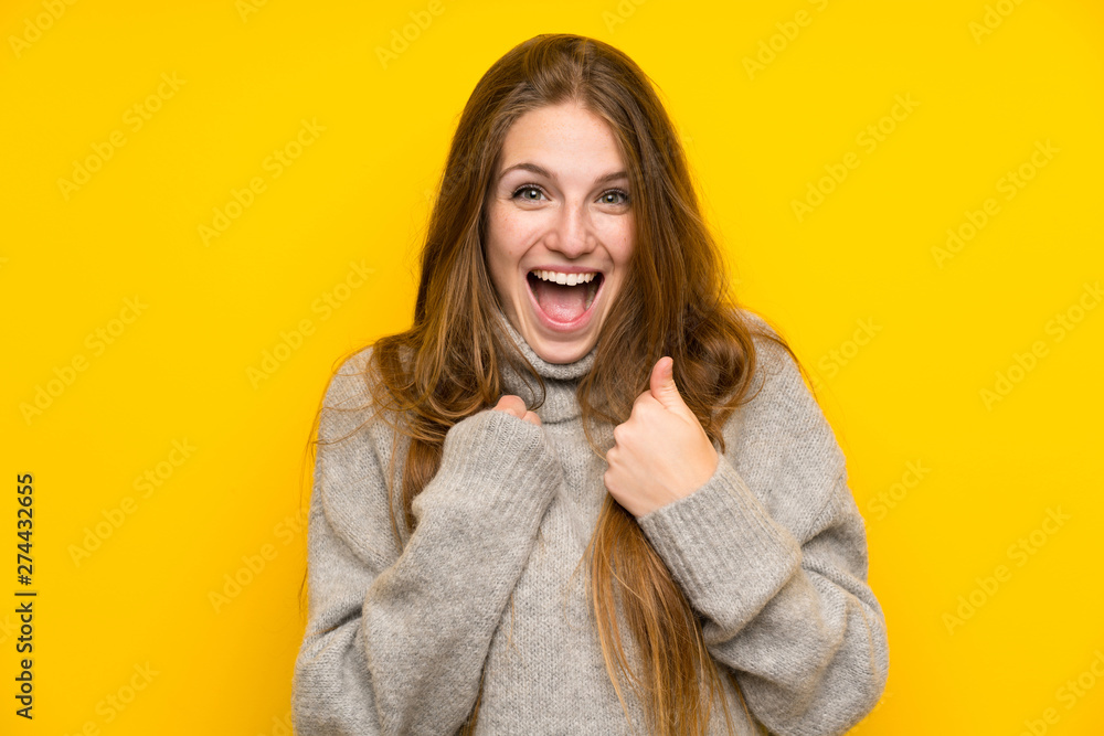 Young woman with long hair over yellow background celebrating a victory Young woman with long hair over yellow background celebrating a victory