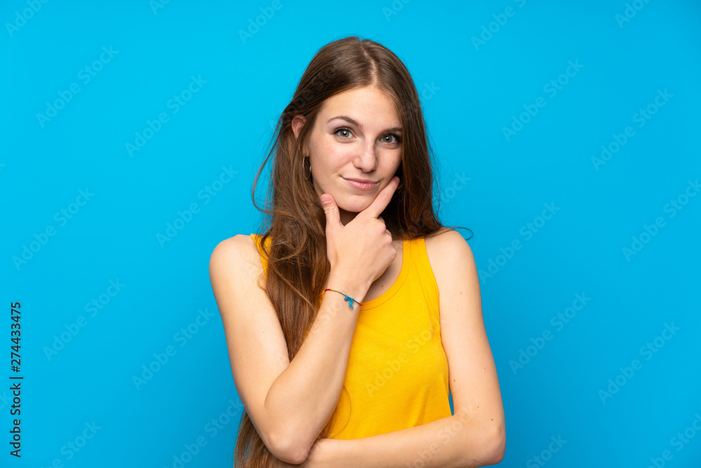Young woman with long hair over isolated blue wall thinking Young woman with long hair over isolated blue wall thinking