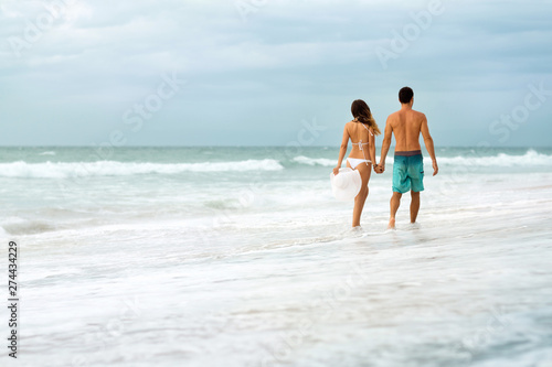 Young couple walking through waves