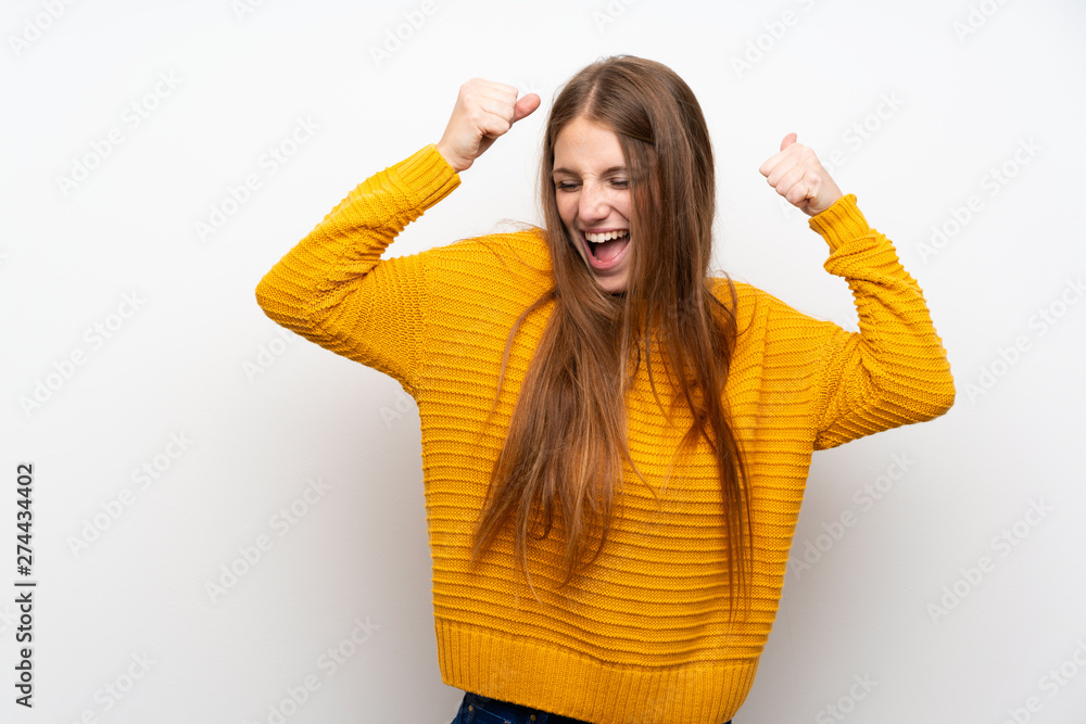 Young woman with yellow over isolated white wall celebrating a victory Young woman with yellow over isolated white wall celebrating a victory