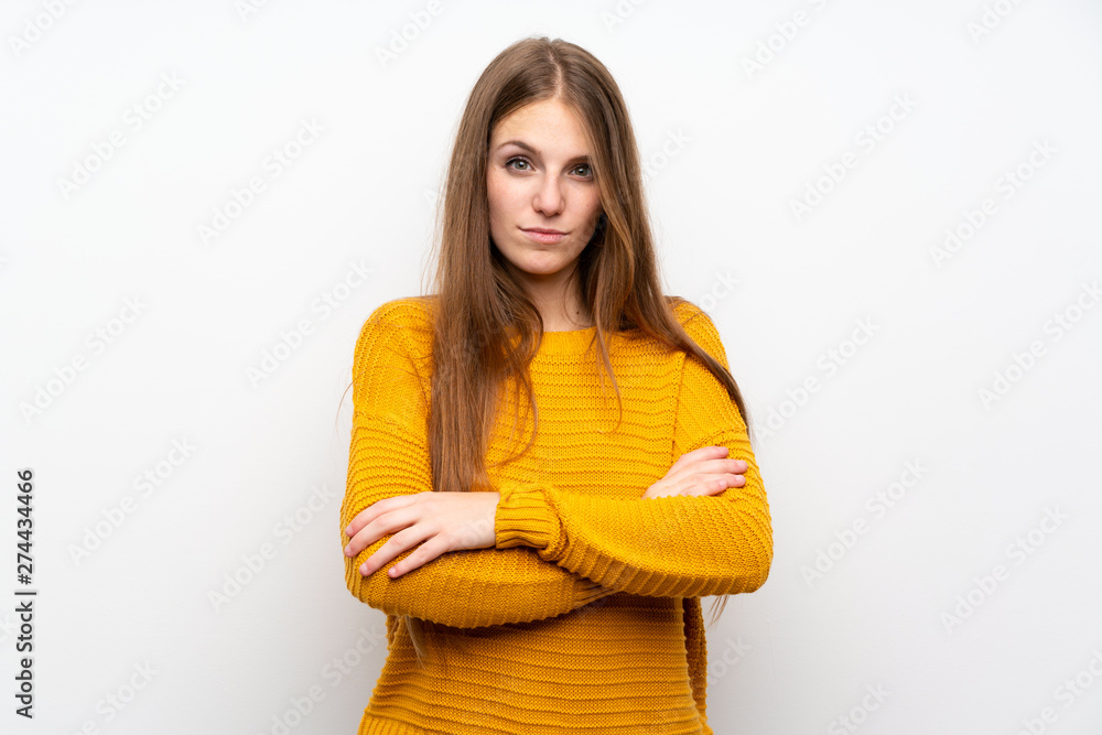Young woman with yellow over isolated white wall keeping arms crossed Young woman with yellow over isolated white wall keeping arms crossed