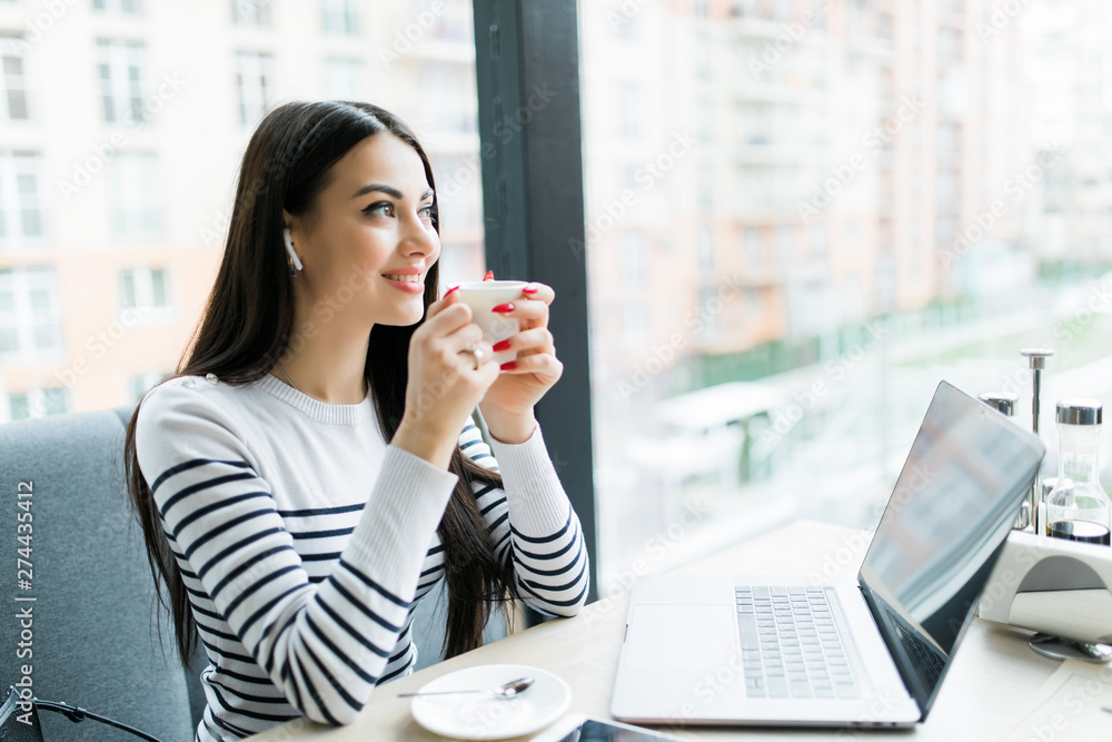 Business woman with laptop working in cafe while drinking coffee Business woman with laptop working in cafe while drinking coffee