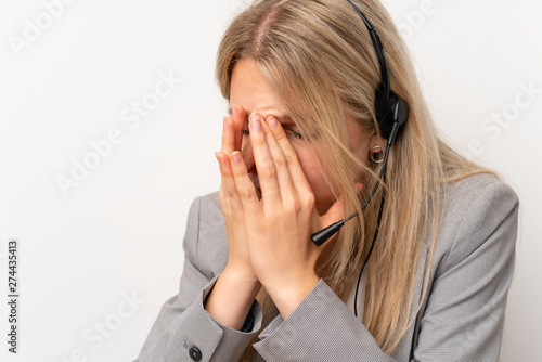 Young woman working with headset in a office with headache