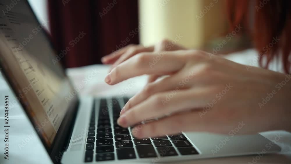 A woman working with a laptop in the hotel room A woman working with a laptop in the hotel room