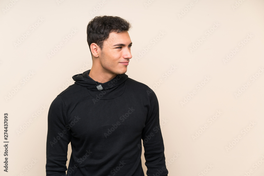 Handsome man over isolated background standing and looking to the side Handsome man over isolated background standing and looking to the side