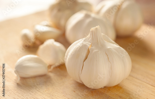 Raw garlic on a wooden plank background