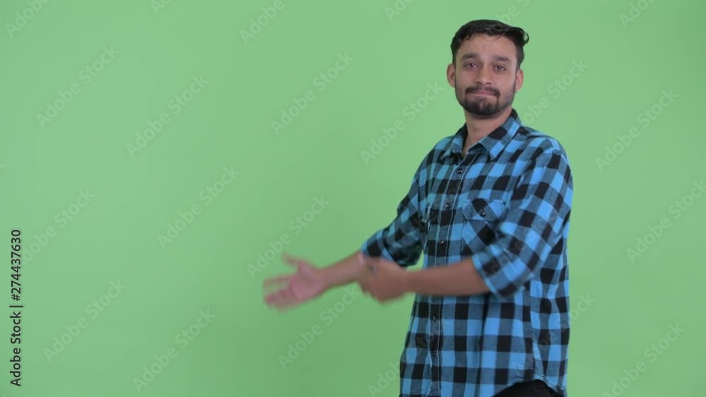 Stressed young bearded Persian hipster man showing to the back Stressed young bearded Persian hipster man showing to the back