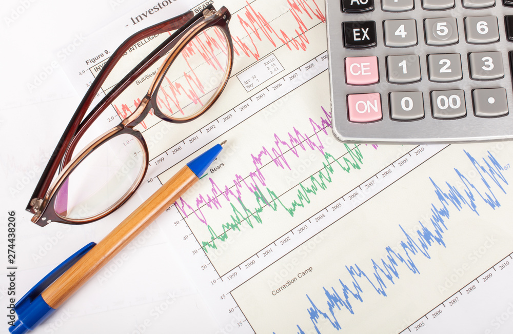 sheet of investment graph report with pen,and calculator sheet of investment graph report with pen,and calculator