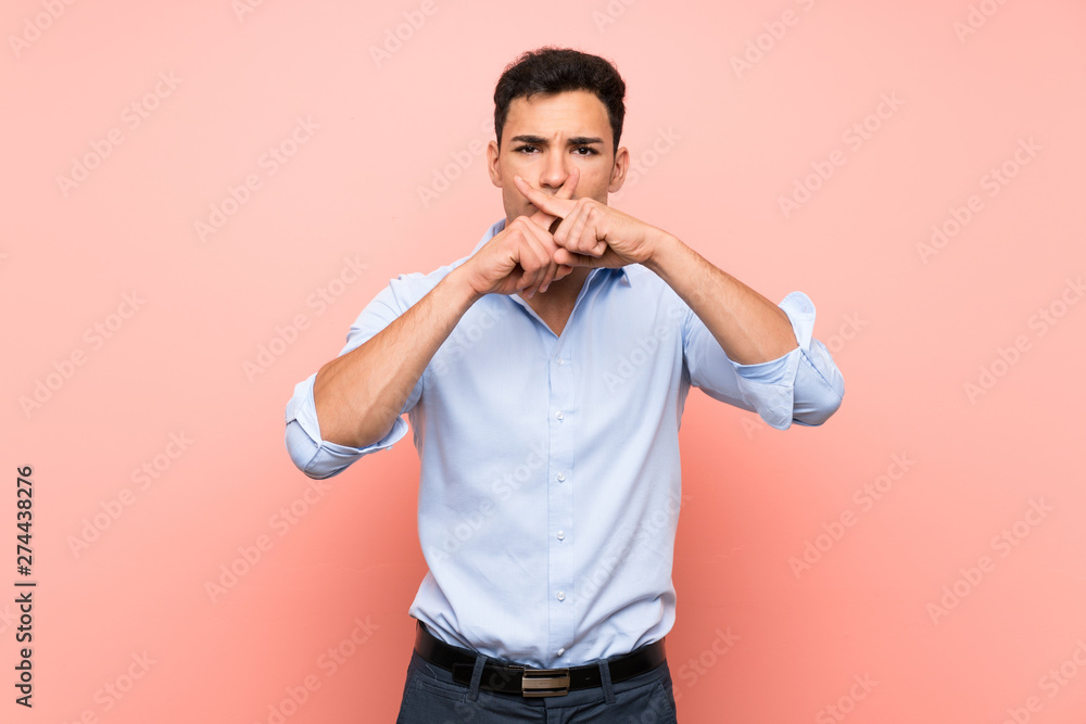 Handsome man over pink background showing a sign of silence gesture Handsome man over pink background showing a sign of silence gesture