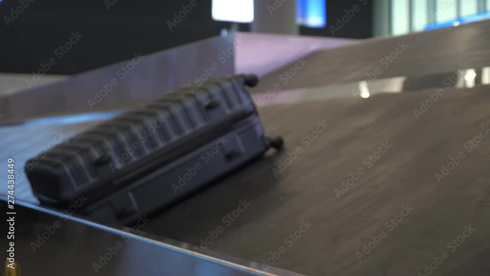 Big grey suitcase is moving on luggage conveyor belt in the airport terminal, closeup view. Big grey suitcase is moving on luggage conveyor belt in the airport terminal, closeup view.