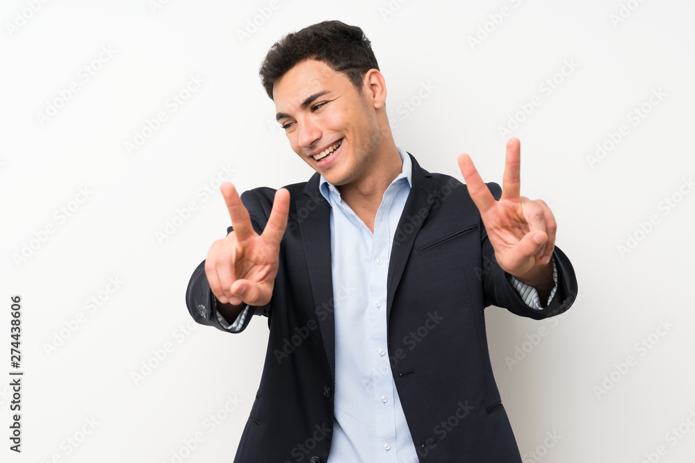 Handsome man over isolated white wall smiling and showing victory sign Handsome man over isolated white wall smiling and showing victory sign