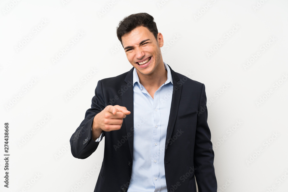 Handsome man over isolated white wall points finger at you Handsome man over isolated white wall points finger at you