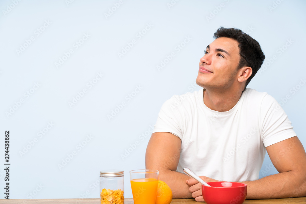 Handsome man in having breakfast laughing and looking up Handsome man in having breakfast laughing and looking up