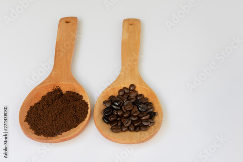 Café en grano y molido sobre cucharas de madera