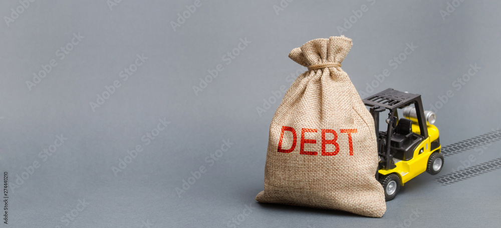 Φωτογραφία Yellow forklift truck can not lift the bag with the inscription debt