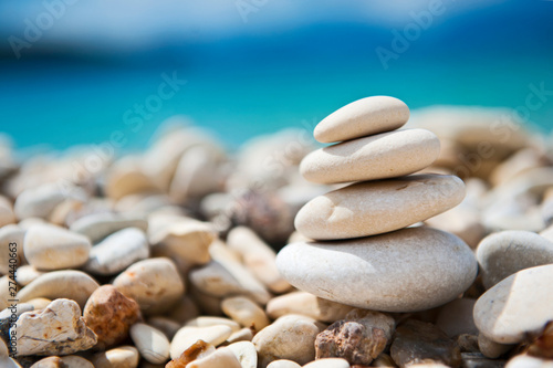 Feng Shui elements. Concept harmony.  White stones and turquise sea in moments of relaxation. Beautiful beach with sand and stone. Zen stones sand. Mikros Gialos beach  Lefkada  Greece.