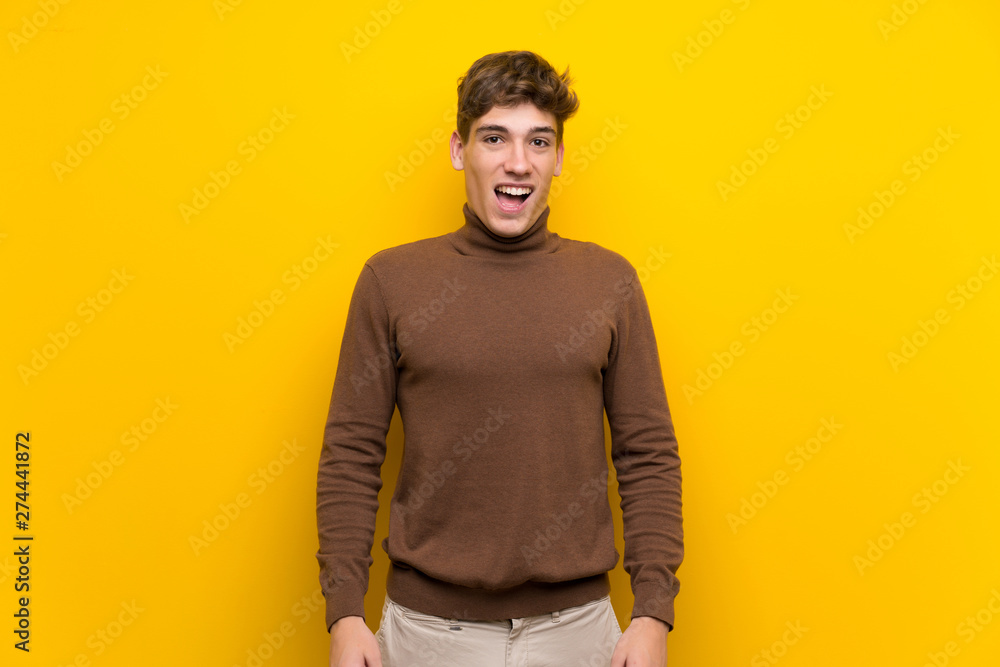 Fototapeta premium Handsome young man over isolated yellow background with surprise facial expression