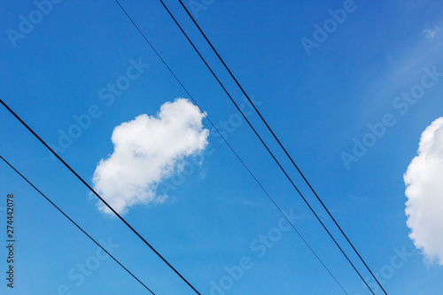 high voltage electricity line with blue sky and clouds behind it.