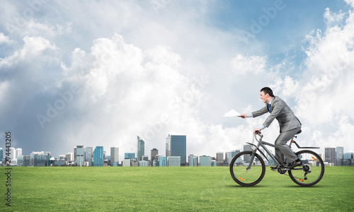 Businessman with paper documents in hand on bike © adam121
