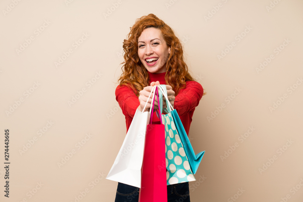 Redhead woman with turtleneck sweater holding a lot of shopping bags Redhead woman with turtleneck sweater holding a lot of shopping bags