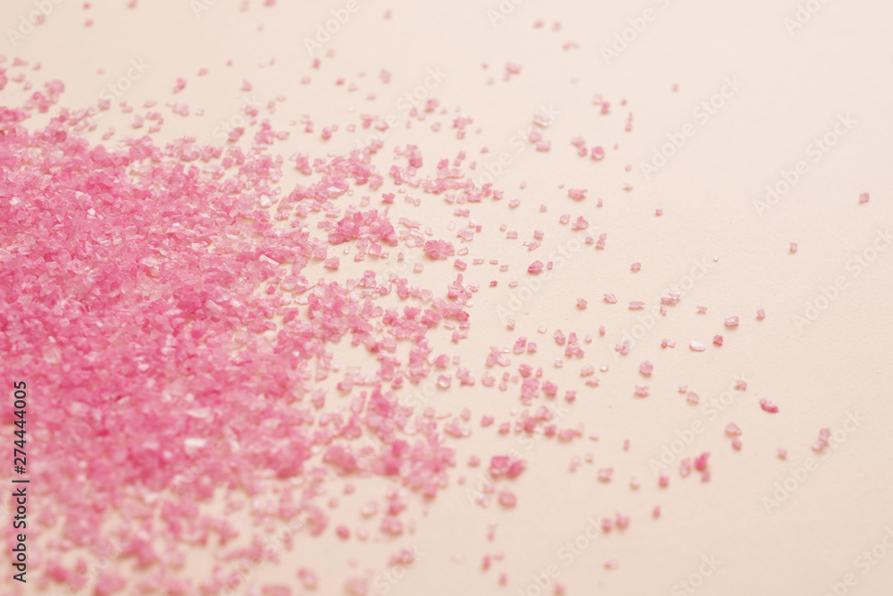 Spa therapy. Pink bath salt crystals scattered over peach surface. Abstract background. Copy space.