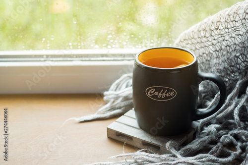 Cup hot tea with lemon on the windowsill Woolen plaid. Autumn still life. It's raining outside. Copy space