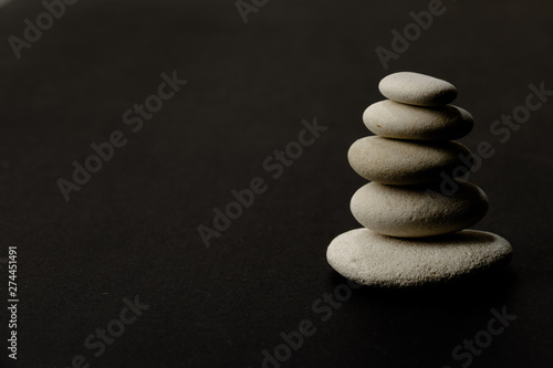 stack of zen stones on the right side dark background and shadows