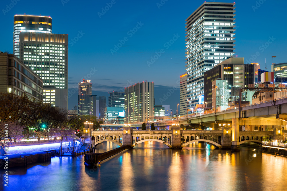 Naklejka premium Osaka skyscraper building in Nakanoshima district at night in Osaka, Japan