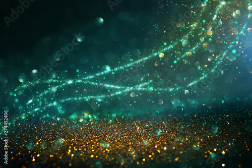 abstract glitter lights background. black, blue, gold and green. de-focused