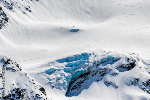 back country skier uphill tracks in the snow above the glaciers crevasse