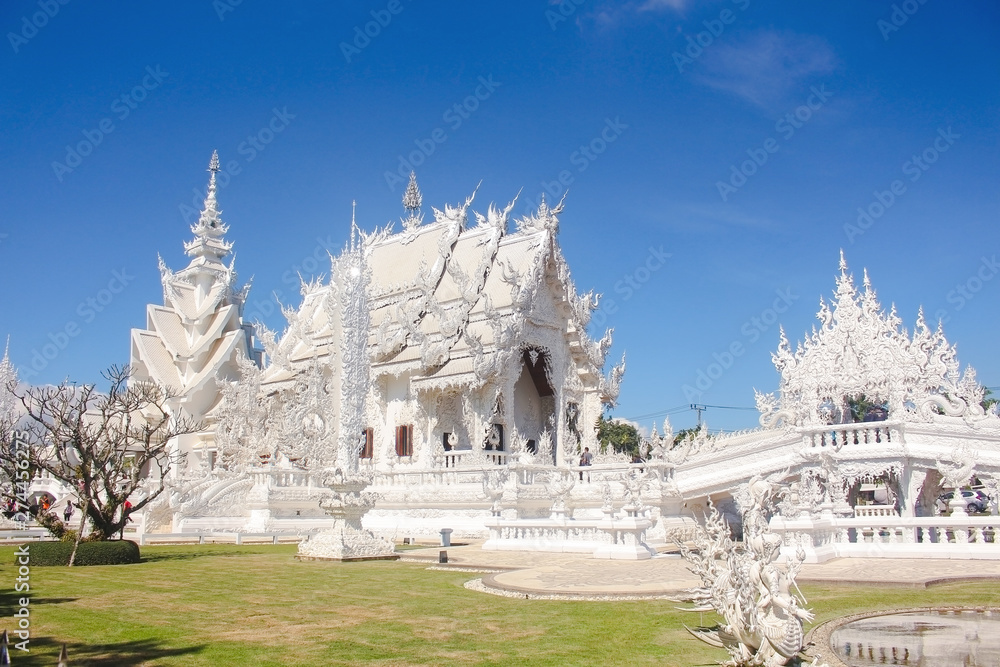 Bridge of 'the cycle of rebirth' and the ornate building of White Temple in a bright day. Chiang Rai province, Thailand