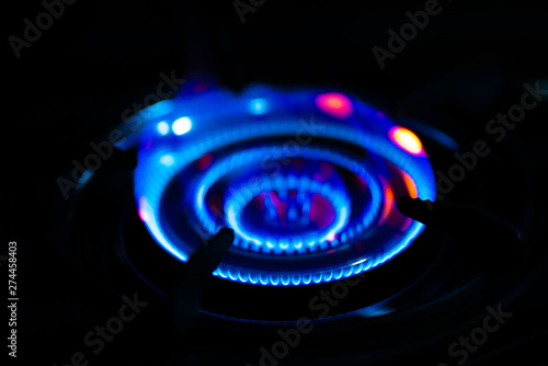 Blue of fire burning in kitchen on the dark background.