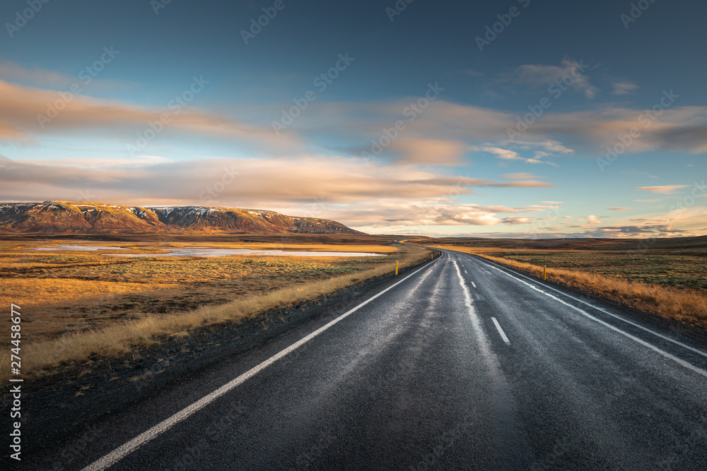 Landscape in Iceland waterfall sun mountains light golden hour road