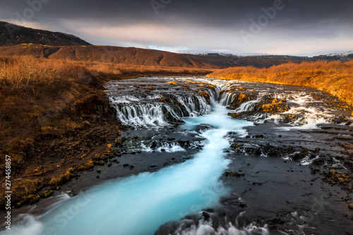 Fototapeta Naklejka Na Ścianę i Meble -  Landscape in Iceland waterfall sun mountains light golden hour road