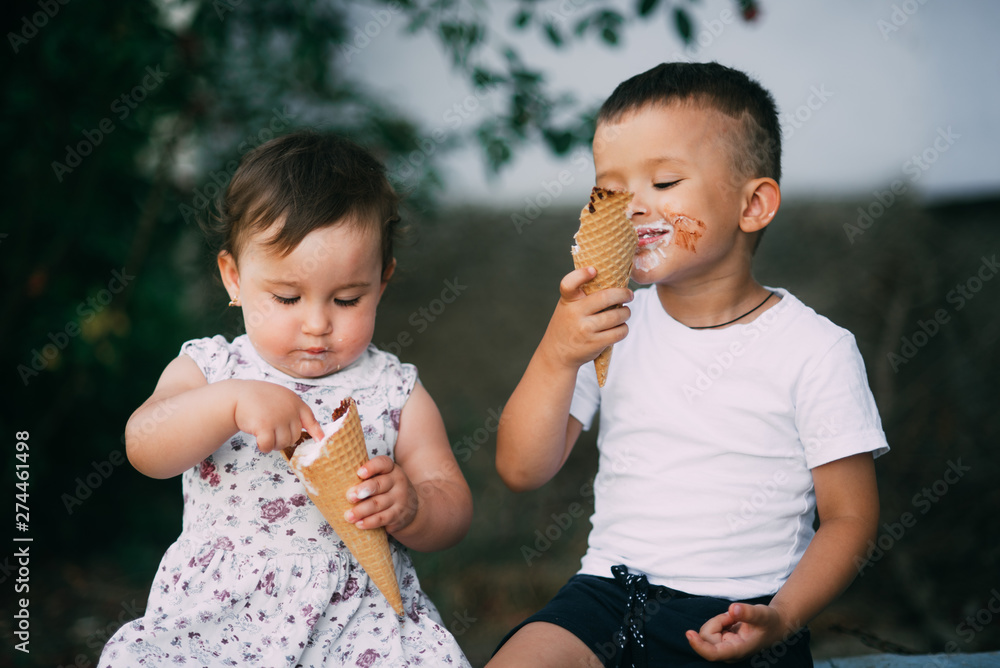 Cute kids Brother and sister are very cute outside in summer eating ice cream in the horn Cute kids Brother and sister are very cute outside in summer eating ice cream in the horn