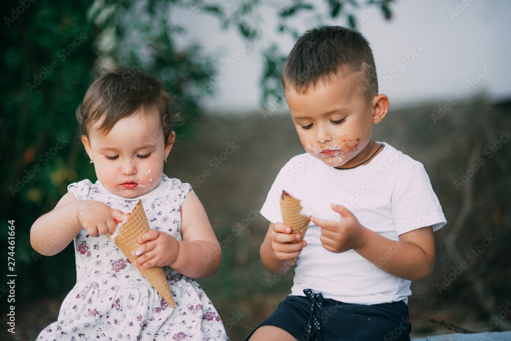 Cute kids Brother and sister are very cute outside in summer eating ice cream in the horn Cute kids Brother and sister are very cute outside in summer eating ice cream in the horn