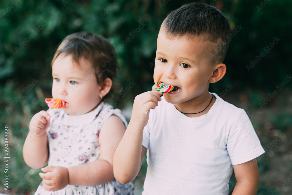 Cute kids eating candy outdoors in the summer very nice Cute kids eating candy outdoors in the summer very nice