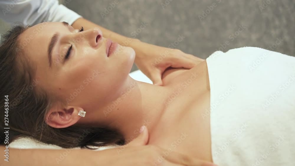 Beautiful woman is lying on massage table and getting luxury service of body skin care and alternative healthy treatment. Attractive adult brunette closed eyes on therapy. Professional beauty Beautiful woman is lying on massage table and getting luxury service of body skin care and alternative healthy treatment. Attractive adult brunette closed eyes on therapy. Professional beauty