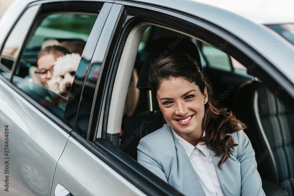 Young businesswoman with her daughter in a car.