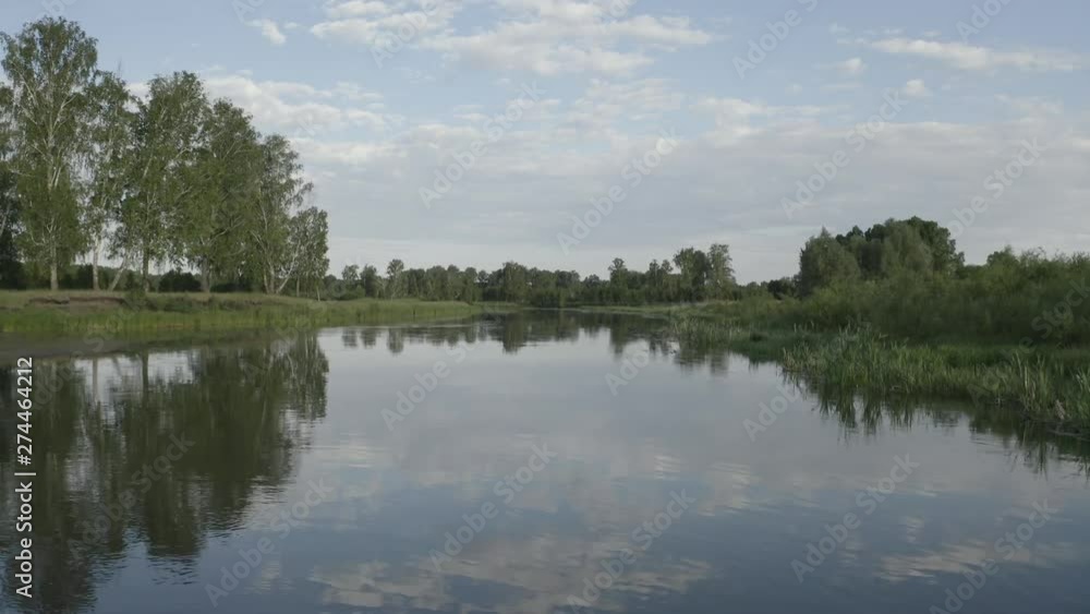 very quiet river, calm, many trees grow on the banks of the birds fly, there are no clouds, the sky is reflected in a clean cool river very quiet river, calm, many trees grow on the banks of the birds fly, there are no clouds, the sky is reflected in a clean cool river
