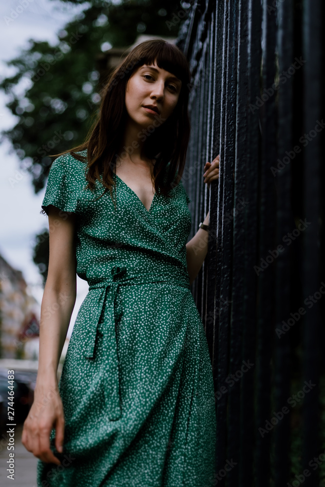 Fototapeta premium young woman in green dress looking into the camera