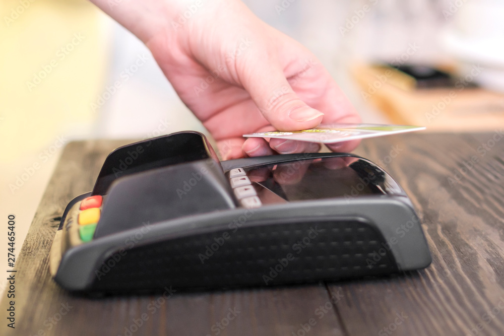 Closeup of woman's hand paying with contactless smart card Closeup of woman's hand paying with contactless smart card