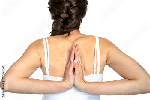 Mujer con hiperlaxitud articular. Palmas de las manos apoyadas en cruz por detrás de la espalda. Fondo blanco.