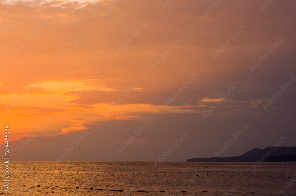 Obraz premium Amazing sea sunset on the pebble beach, the sun, waves, clouds