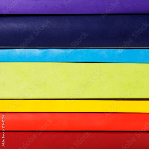 Stack of colorful rainbow books on white background